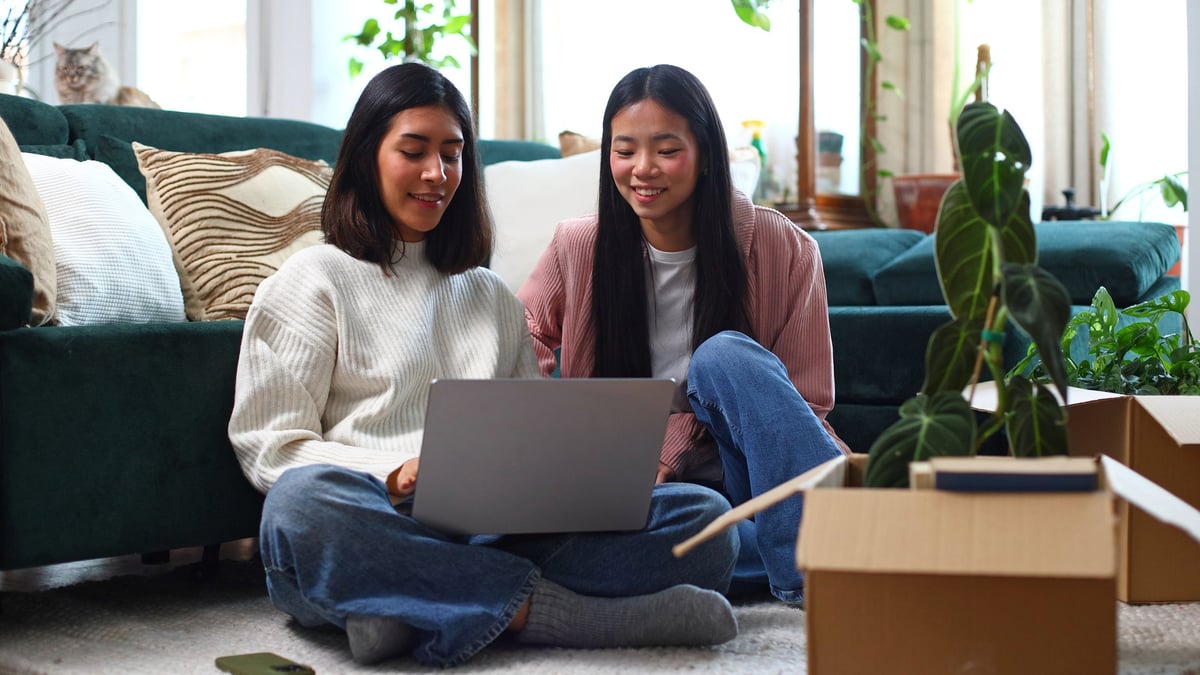 College roommates studying with laptops in shared off-campus living space near Penn State University